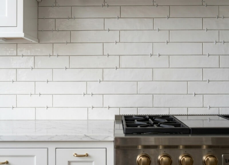 White ceramic subway tile kitchen backsplash installation in progress.
